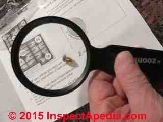 Use a magnifying glass to read spud orifice numbers when converting a gas cooktop between LPG and Natural gas (C) Daniel Friedman