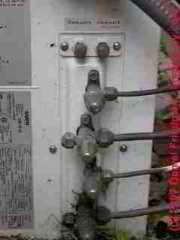 Photograph of the high and low pressure air conditioning refrigerant lines and service ports on an air conditioning compressor/condenser