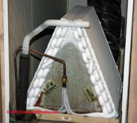 Photograph of attic air conditioning air handler, condensate drips on floor