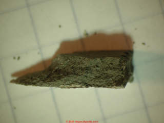 Asphalt asbestos floor tile edge showing black matrix of constituents (C) Daniel Friedman at InspectApedia.com