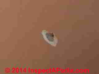 Plaster wall with damage at nail hole (C) InspectApedia LN