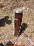 Photograph of  a modern steel well casing and cap extending properly above grade level and properly capped. You can see from
the gray plastic conduit that electrical wires enter the well, informing you that this well is served by an in-well submersible well pump.