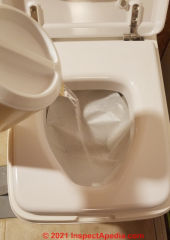 Use clean water to add weight to the paper incinerating toilet paper bag liner if necessary to get it to flush (C) InspectApedia.com