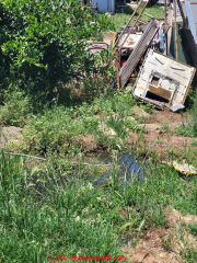 neighbor yard sewage and trash heap (C) InspectApedia.com Stinky LePew