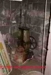 Antique well pump on steel casing under a home © D Friedman at InspectApedia.com 