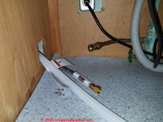 Pulling the dishwasher supply & drain lines & electrical connector into the under-sink area as the dishwasher slides into place (C) Daniel Friedman at InspectApedia.com