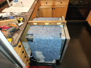 Check the level condition of the floor on which the dishwasher will sit to estimate the amount of adjustment needed to its feet (C) Daniel Friedman at InspectApedia.com