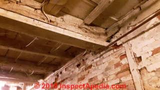 Structural damage to wood beam, sill, brick and stone foundation wall (C) InspectApedia.com John