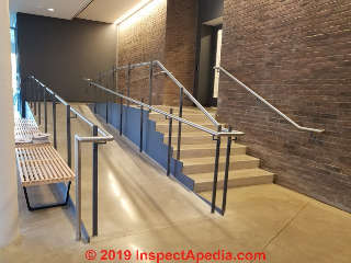 Metal Newel post set into concrete floor slab, glass stair and ramp guards, Vassar College Poughkeepsie NY (C) Daniel Friedman at InspectApedia.com