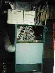 Photograph of older side-vent combination hot air furnace and central air conditioning system. The evaporator coil or A-coil is visible in the top of the unit.