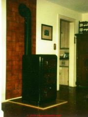 Coal stove installed sharing chimney with a gas fired heating boiler in a New York home - removed by the author as unsafe (C) Daniel Friedman at InspectApedia.com