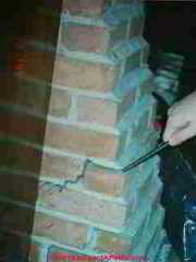 Photograph of a brick chimney cracked exterior, possibly due to heat.