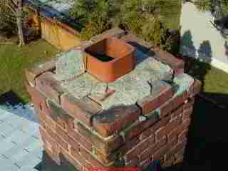 Photograph of a damaged masonry chimney.