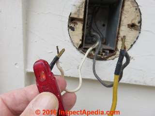 Using a neon tester to check for power at electrical wires (C) Daniel Friedman