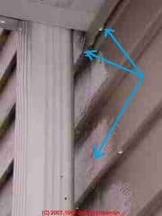 Photograph of gutter leak running down vinyl siding.