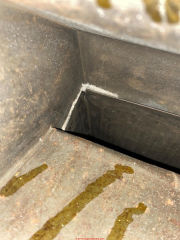 Apparent asbestos gasket exposed in air path in HVAC duct - wet rusty ductwork (C) InspectApedia.com Joe