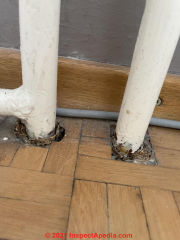 Asbestos pipe insulation at passage through floor (C) InspectApedia.com Trin