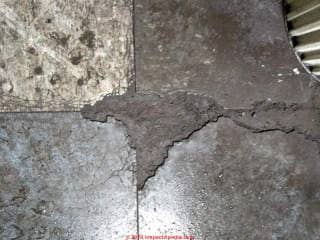 Damaged asphalt asbestos flooring (C) InspectApedia.com Bush