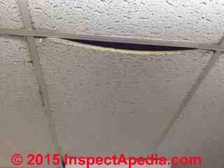 Sagging suspended ceiling tile (C) InspectAPedia.com