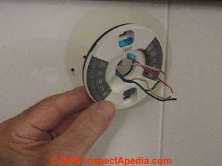 Placing new Nest thermostat base over the wires and in position (C) Daniel Friedman