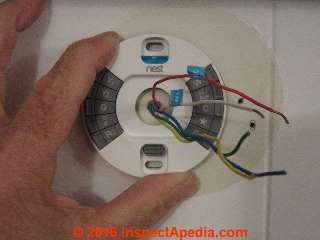 Nest 3 thermostat held in position where it will be installed (C) Daniel Friedman