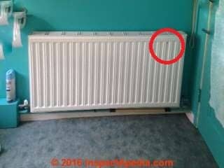 Steel heat sink or night storage radiator on a Scottish biomass boiler hot water heating system - leak is circled in red (C) InspectApedia.com 2016