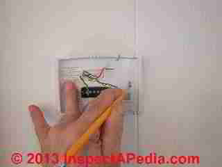 Positioning new wall thermostat in place (C) Daniel Friedman