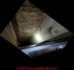 White stuff, maybe mold or maybe effloresence on the under side of OSB subflooring (C) InspectApedia.com Tom