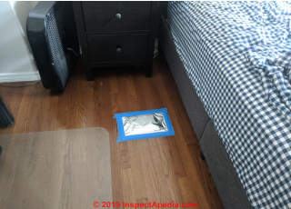 Smell patch test kit being applied to a hardwood floor in a room with trouiblesome persistent odors (C) InspectApedia.com Chris