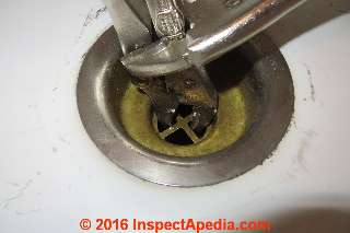 Using a pair of Vise Grip locking pliers to grab the slipping sink strainer assembly from above (C) InspectApedia.com Daniel Friedman