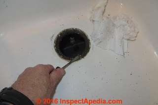 Cleaning the sink after sink strainer baseket removal (C) InspectApedia.com Daniel Friedman