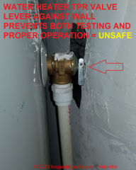 Water TPR valve handle tight against wall prevents both testing and operating in response to over-pressure ore over-temperature- this is an unsafe installation (C) InspectApedia.com A Puentes