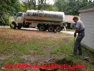 PHOTO of operator breaking up septic tank sludge layer 