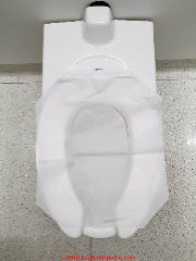 Disposable flushable toilet seat paper cover at Chicago O'Hare airport (C) Daniel Friedman at InspectApedia.com