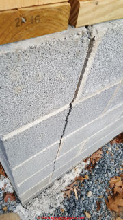 Vertical crack at the corner of a concrete block wall usually means rotating footing or settling, tipping footing (C) Daniel Friedman at InspectApedia.com