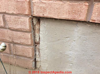 Crack in masonry wall abutting brick veneer (C) InspectApedia.com Andrew