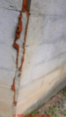 Foam-sealed vertical crack at block foundation corner is not a repair (C) InspectApedia.com Ulanda