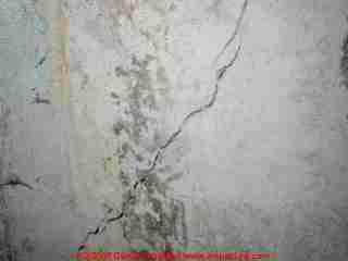 Photograph of a substantial settlement crack in poured concrete.