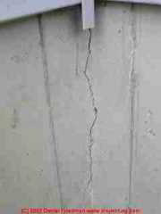 Photograph of a substantial settlement crack in poured concrete.