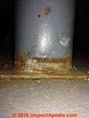 Dent & rust on hollow steel column in a garage (C) InspectApedia.com ES