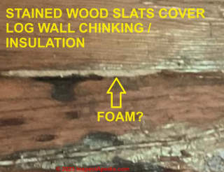 Arrows point to what might be foam insulation or other log chinking material. (C) InspectApedia.com Sandie