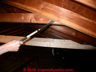 Removing the old collar ties before straightening the roof and adding new collar ties (C) InspectApedia.com Daniel Friedman Jess Aronstein