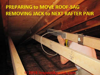 Roof sag removing expander hangs by rope to step from rafter pair to rafter pair during the roof sag removal project (C) Jess Aronstein Daniel Friedman InspectApedia.com