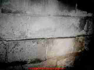 Photograph of - bowed foundation wall, probably from frost cracking. Drop a plumb line to measure total inwards bulging of this block foundation wall.