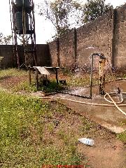 Overflowing borehole probably artesian well out of control (C) InspectApedia.com Ajayi