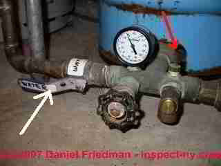 Photograph of a water pressure tank air valve, relief valve and main water shutoff 