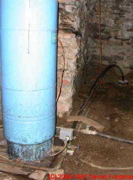 Antique well pump on steel casing under a home © D Friedman at InspectApedia.com 