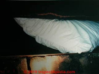 Pillow stuffed into a fireplace instead of a working fireplace damper (C) Daniel Friedman at InspectApedia.com