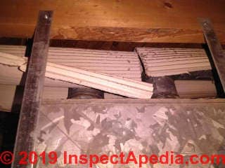 Corrugated asbestos paper used as HVAC duct insulation, loose, poor condition (C) InspectApedia.com Marks
