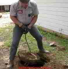 Photograph of a septic cleaning contractor opening a septic tank for inspection and pumping.